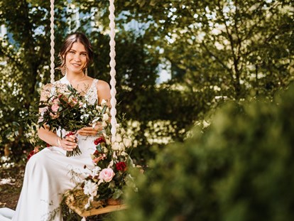 Hochzeit - Hochzeits-Stil: Modern - Mondsee - Braut auf Hochzeitsschaukel - ARCOTEL Castellani Salzburg