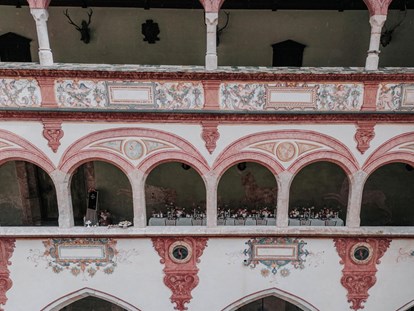 Hochzeit - Hochzeits-Stil: Rustic - Hall in Tirol - Lange Tafel in den überdachten Arkaden mit Blick in den Innenhof - Schloss Tratzberg