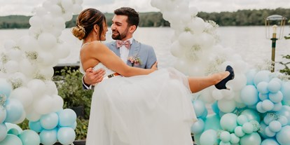 Hochzeit - Hochzeits-Stil: Boho-Glam - Altlandsberg - Ein glückliches Paar nach der freien Trauung auf unserem Tiny Beach mit einer festlichen Ballon Dekoration im Hintergrund - Richtershorn am See