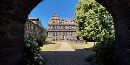 Hochzeit - Personenanzahl - Helferskirchen - Blick durch das Eingangstor in den Innenhof und das Schloss Friedewald - Schloss Friedewald (Westerwald)