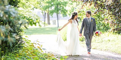Hochzeit - Umgebung: im Park - Weiden am See - Das Brautpaar auf dem Weg zur Tafel. - Birkenhof Restaurant & Landhotel ****