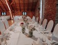 Hochzeit: Brauttafel mit edlen Stuhlhussen vor der historischen Steinmauer  - Eventtenne - Hochzeits- & Veranstaltungslocation