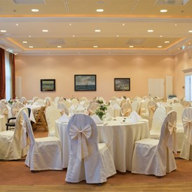 Hochzeit: Festlich geschmückter Ballsaal für eine große Hochzeitsgesellschaft im Bernsteinpalais - Vju Hotel Rügen