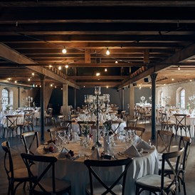 Hochzeit: Der Festsaal hat nahezu komplett seine rustikale und industrielle Anmutung behalten und wurde liebevoll restauriert. Die Holzdecke harmoniert perfekt mit den alten Sprossenfenstern. - Eichenstolz