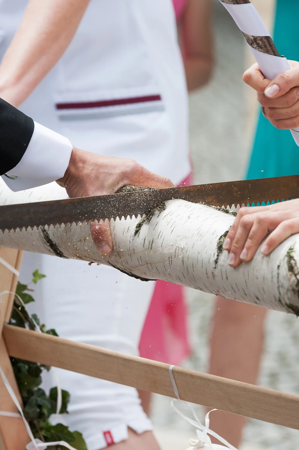 Sawing the tree trunk symbolizes the cooperation and unity of the bride and groom.