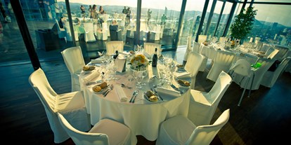 Hochzeit - Standesamt - Wien - Runde Tische im Innenbereich der Wolke21 mit Blick auf Wien. - wolke21 im Saturn Tower