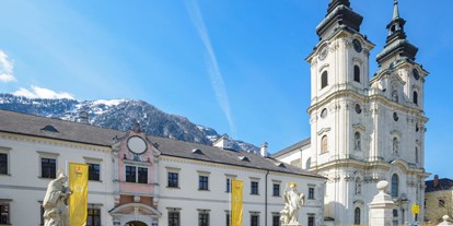 Hochzeit - Alpenregion Nationalpark Gesäuse - Hoteleingang mit der wunderschönen Stiftskirche - JUFA Hotel Pyhrn Priel