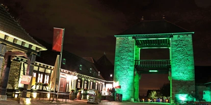 Nozze - Art der Location: Weingut/Heuriger - Annweiler am Trifels - Das Deutsche Weintor leuchtet in grün.  - Deutsches Weintor Restaurant