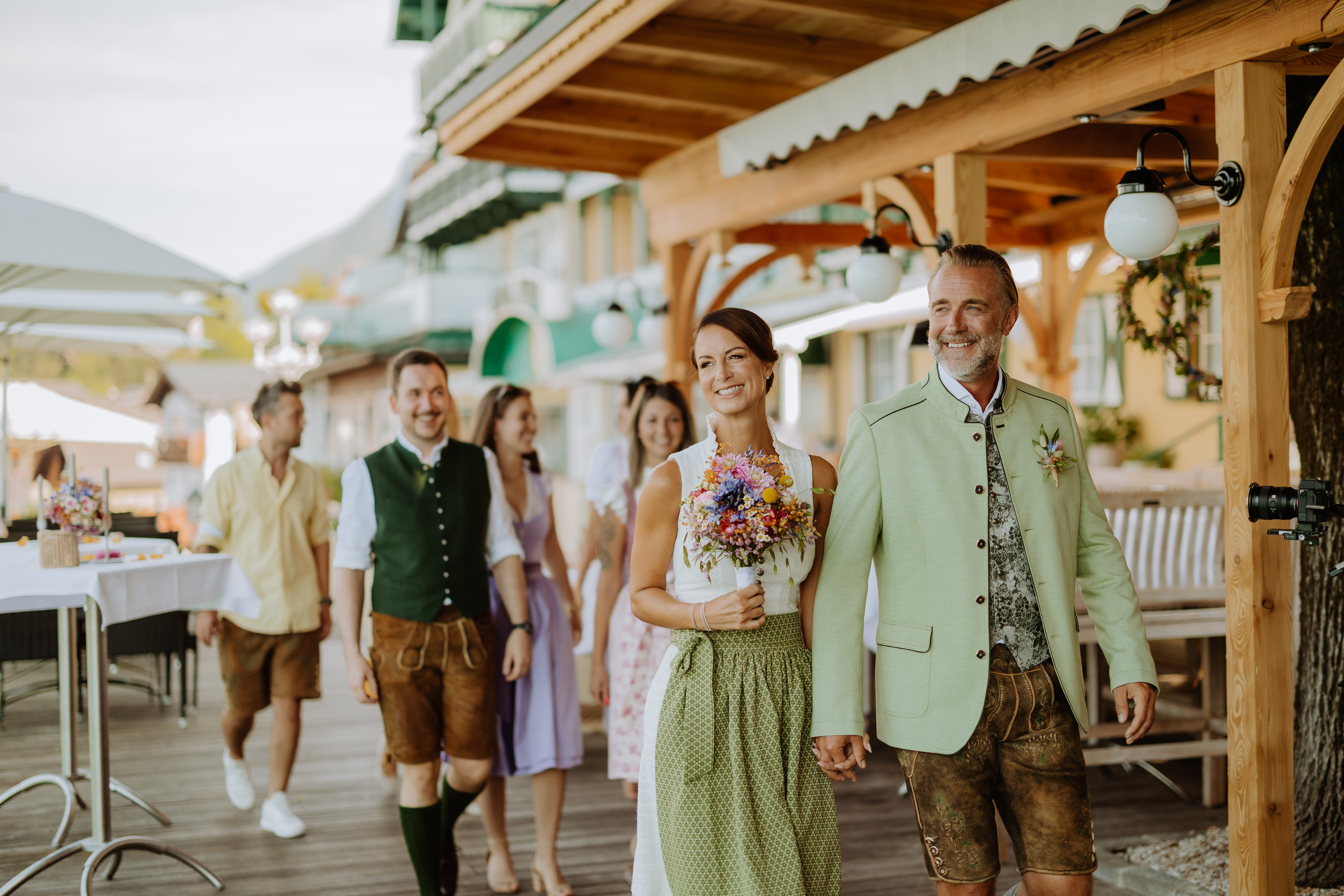 Hochzeit - Standesamt - Salzkammergut - Hochzeitspaar mit Gästen gehen über die Seeterrasse im Restaurant Paul der Wirt - Paul der Wirt, St. Wolfgang