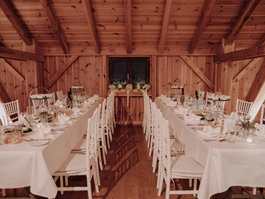 Hochzeitslocation: Lange Tafeln in den Seitennischen der Tenne - Eventtenne - Hochzeits- & Veranstaltungslocation