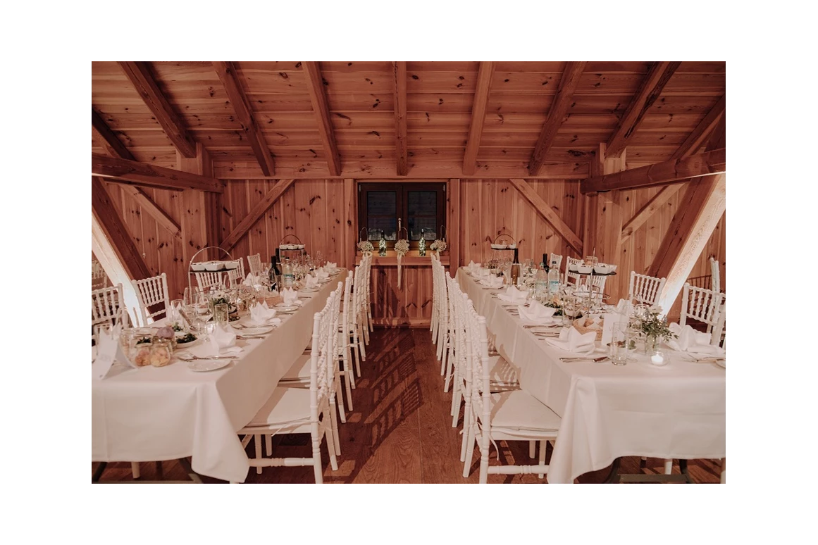 Hochzeitslocation: Lange Tafeln in den Seitennischen der Tenne - Eventtenne - Hochzeits- & Veranstaltungslocation