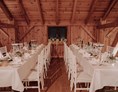Hochzeit: Lange Tafeln in den Seitennischen der Tenne - Eventtenne - Hochzeits- & Veranstaltungslocation