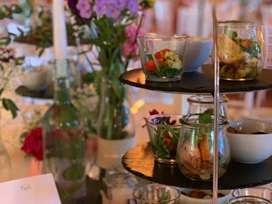 Hochzeitslocation: Vorspeisenbuffet auf den Gasttischen elegant angerichtet auf schönen Etageren - Eventtenne - Hochzeits- & Veranstaltungslocation