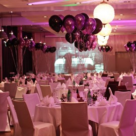 Hochzeit: Runde Tische bestuhlt mit Hussen und farblich abgestimmten Ballons - Hotel Altes Stahlwerk
