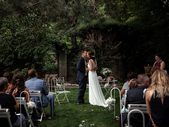 Hochzeit: Der Erste Kuss als Vermähltes Paar inmitten der großen Gartenlandschaft des Junghof in Undenheim. - JUNGHOF Weingut & Gutsgastronomie