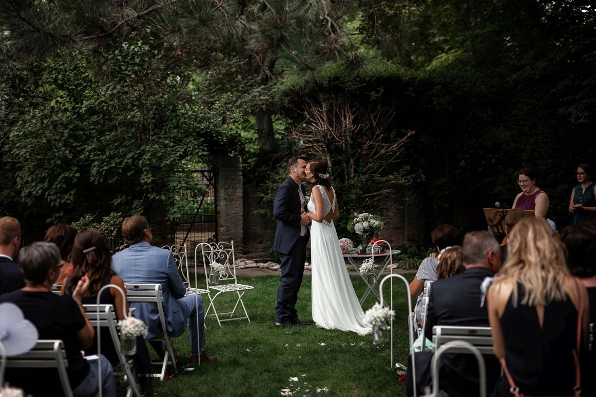 Hochzeit: Der Erste Kuss als Vermähltes Paar inmitten der großen Gartenlandschaft des Junghof in Undenheim. - JUNGHOF Weingut & Gutsgastronomie