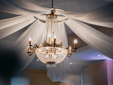 Hochzeitslocation: Der große Luster und die Stoffe verwandeln den Festsaal in ein Wunderland für eure Hochzeit. - Café Wildau - Werbellinsee