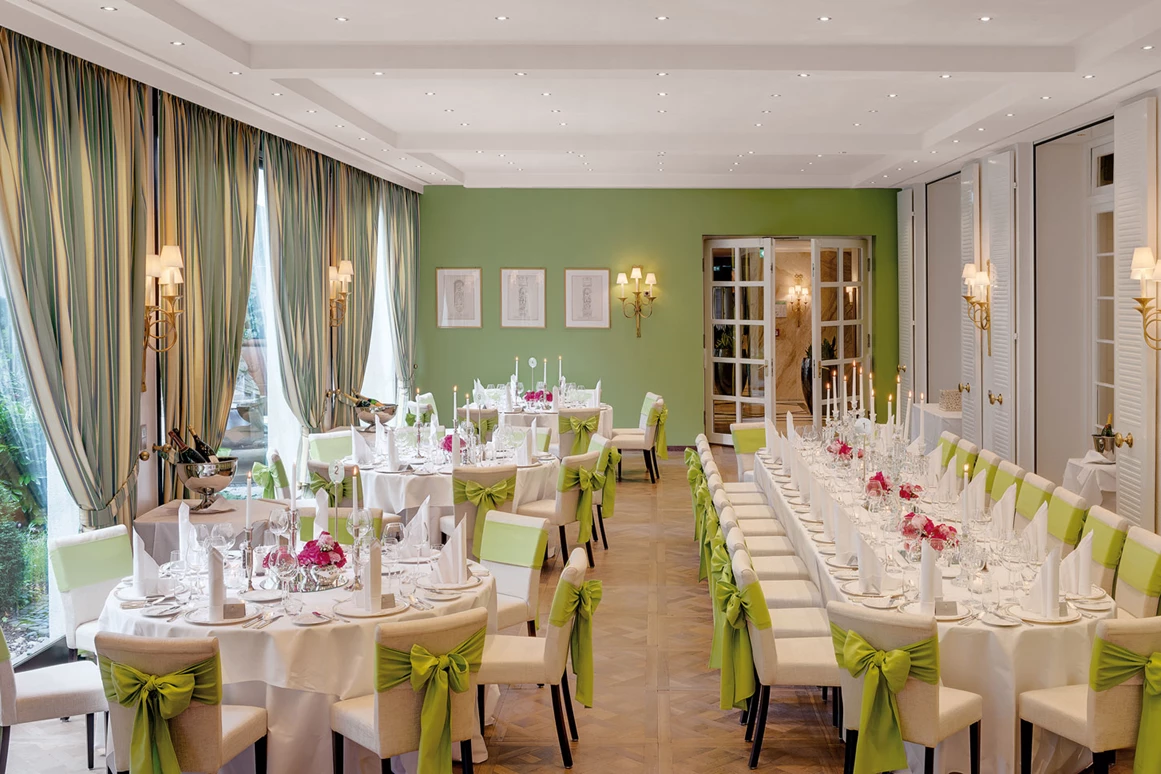 Hochzeitslocation: Ein traumhaftes Ambiente für Ihre Hochzeit in Heidelberg verspricht unser Gartensaal. Seine Grün- und Weiß-Töne versprühen sommerliches Flair und Heiterkeit. Hier erleben Sie eine märchenhafte Hochzeitsfeier mit bis zu 100 Gästen. Auf Wunsch lässt sich der Gartensaal in zwei Räume unterteilen – ideal, wenn Sie die Tanzfläche vom Bankettbereich separieren möchten. Bei schönem Wetter lassen sich die großen Fensterscheiben komplett in den Boden versenken und Sie können im mediterran gestalteten Innengarten flanieren. - Hotel Europäischer Hof Heidelberg