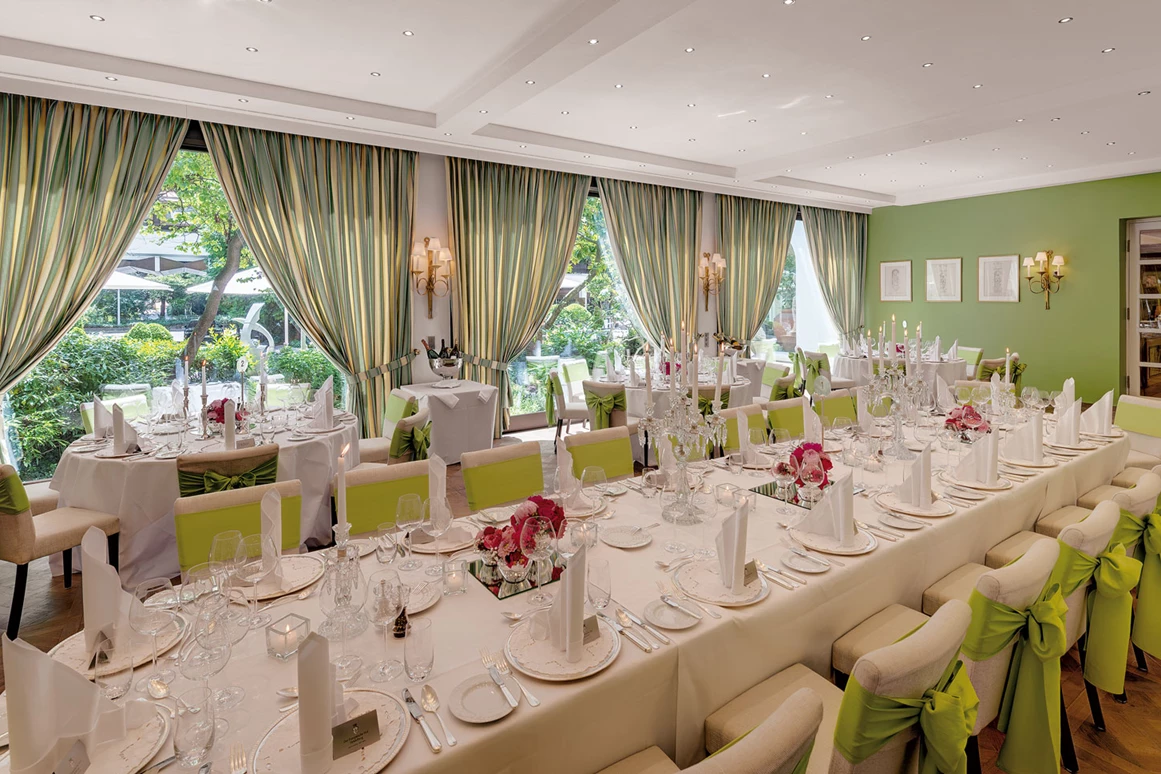 Hochzeitslocation: Ein traumhaftes Ambiente für Ihre Hochzeit in Heidelberg verspricht unser Gartensaal. Seine Grün- und Weiß-Töne versprühen sommerliches Flair und Heiterkeit. Hier erleben Sie eine märchenhafte Hochzeitsfeier mit bis zu 100 Gästen. Auf Wunsch lässt sich der Gartensaal in zwei Räume unterteilen – ideal, wenn Sie die Tanzfläche vom Bankettbereich separieren möchten. Bei schönem Wetter lassen sich die großen Fensterscheiben komplett in den Boden versenken und Sie können im mediterran gestalteten Innengarten flanieren. - Hotel Europäischer Hof Heidelberg