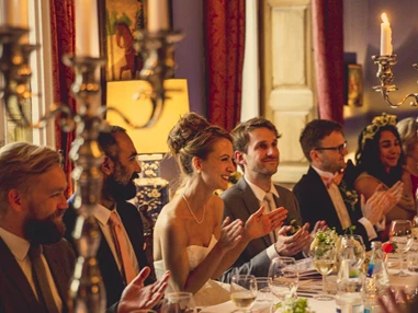 Hochzeitslocation: Das glückliche Brautpaar an der großen Tafel. - Schloss Stülpe