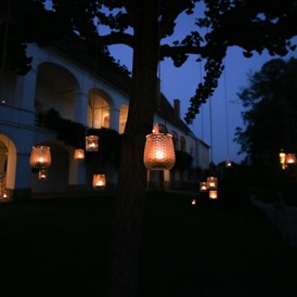Hochzeit: Am Abend wird der Schlosspark in warmes Kerzenlicht getaucht und die Bäume erstrahlen im weitläufigen Park - Schloss Welsdorf