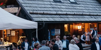 Hochzeit - Ramingstein - Hochzeitsgäste im Freien und Feuerschale - Almgasthof Hiasl Zirbenhütte