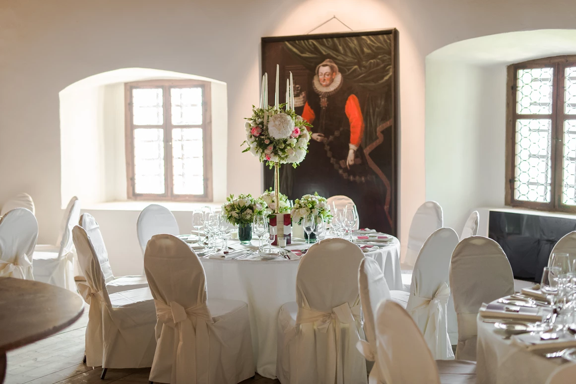 Hochzeit: Der Mitteltrakt von Schloss Friedberg mit offenem Kamin besticht durch seine besondere Raumaufteilung. Er ist sehr gut mit den vor- und nachgereihten Sälen – Freskensaal und Gotischer Knappensaal – zu verknüpfen sowie direkt vom Innenhof aus zu erreichen. Der Fiegersaal zeigt eine Porträtgalerie verschiedener Fürsten, die ein historisches Flair verleiht. - Schloss Friedberg