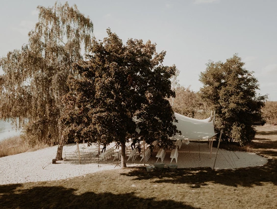 Hochzeitslocation: Das absolute Highlight der Eventlocation ist der Beachbereich inklusive Zelt. Der Blick über den 100.000 qm großen See bietet eine spektakuläre Kulisse für jedes Event – ob Freie Trauung oder ein geselliges Get Together. - Seehaus Forst