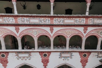 Hochzeit: Lange Tafel in den überdachten Arkaden mit Blick in den Innenhof - Schloss Tratzberg