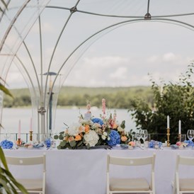 Hochzeit: Eine bunt geschmückte Hochzeitstafel auf unserer Wasserterrasse unter einem anmietbaren Kuppelzelt - Richtershorn am See