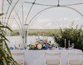 Hochzeit: Eine bunt geschmückte Hochzeitstafel auf unserer Wasserterrasse unter einem anmietbaren Kuppelzelt - Richtershorn am See