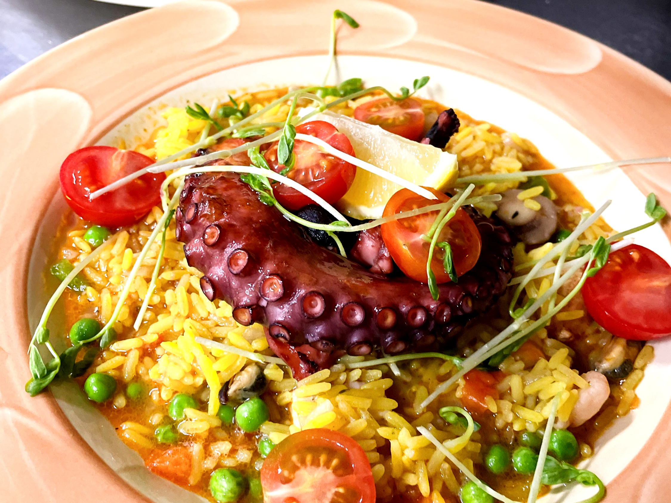 Hochzeitslocation: Butterzarter Oktopus auf spanischer Paella mit goldgelbem Reis und knackigem Gemüse - Hotel und Restaurant Kolossos in Neuss am Rhein