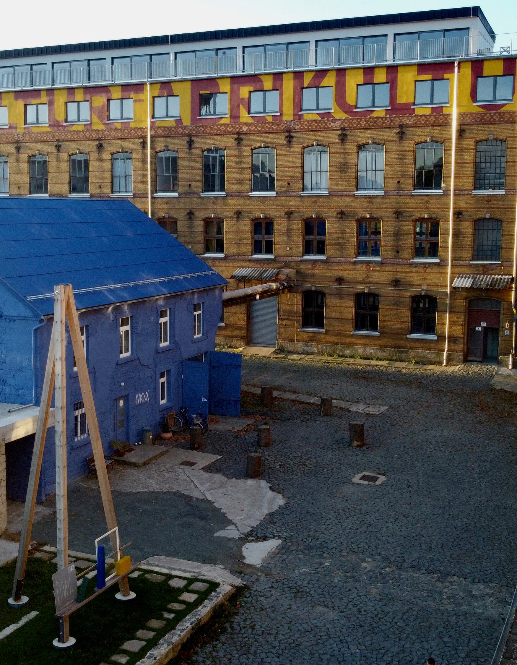 Wedding - Saxony - Hof des Fabrikgeländes, welches gerne für einen Stehempfang genutzt werden kann.
Das "Max" -blaue Haus- ist für keine Veranstaltungen oder für das Frühstück am nächsten Tag gedacht.
Im Fabrikgebäude haben Sie im EG & 1.OG die Feierräume .
Im Obergeschoss, dann unsere Apartments mit Dachterrasse. - Kulturfabrik Schönbach