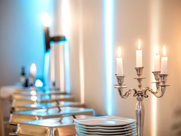 Hochzeit: Gestelltes Buffet mit Kerze im Vordergrund - Französischer Dom und Restaurant Hugo & Notte