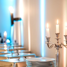 Hochzeit: Gestelltes Buffet mit Kerze im Vordergrund - Französischer Dom und Restaurant Hugo & Notte