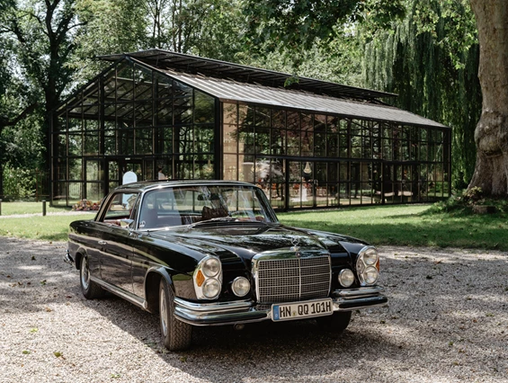 Hochzeitslocation: Ein Oldtimer vor der Orangerie des Schlossgut Lautenbach. - Schlossgut Lautenbach