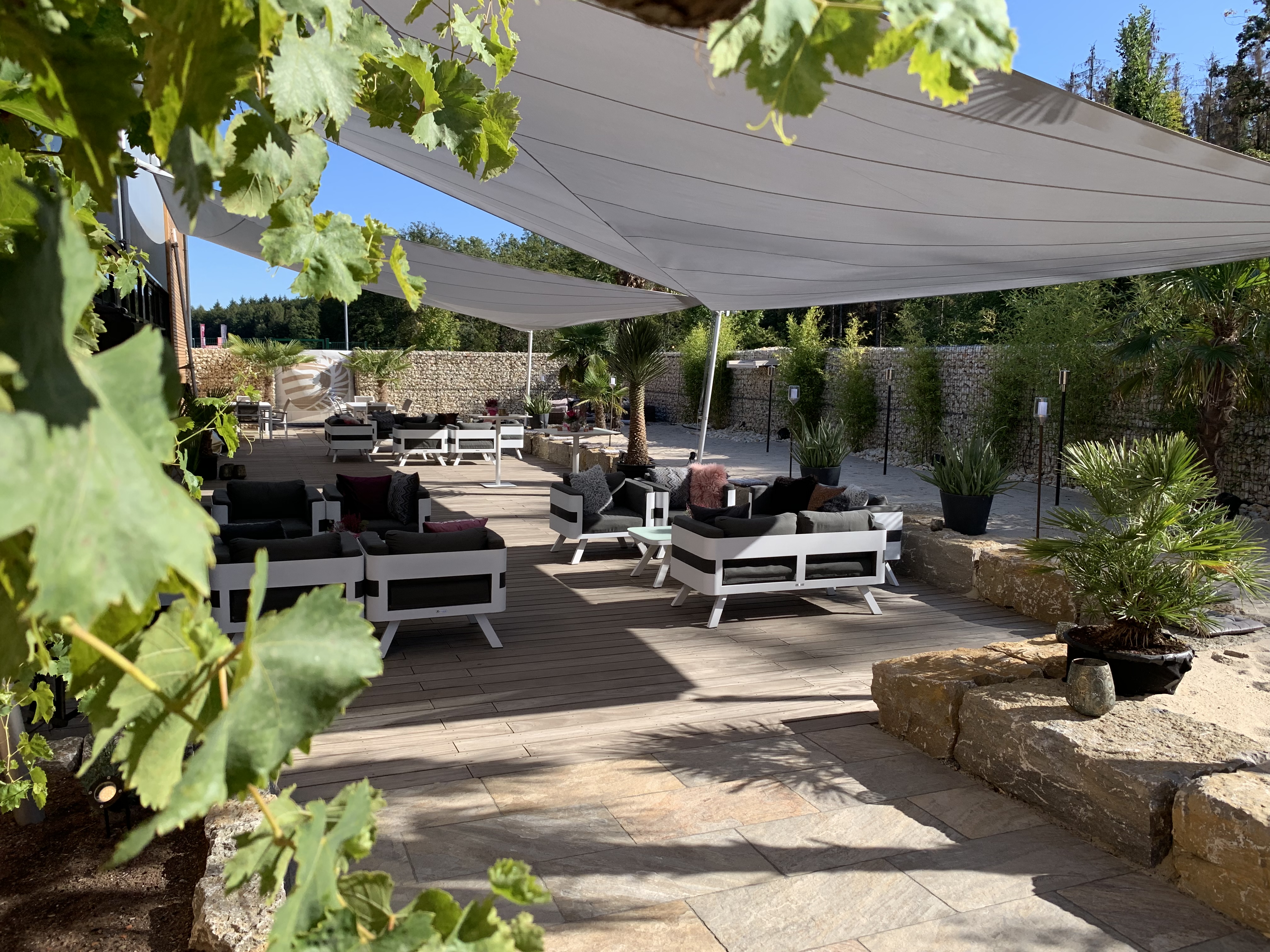 Hochzeitslocation: Loungemöbel im Garten der Premiumlocation Botanical, das Beachhouse in Hessen. - Hochzeits- und Eventlocation BOTANICAL