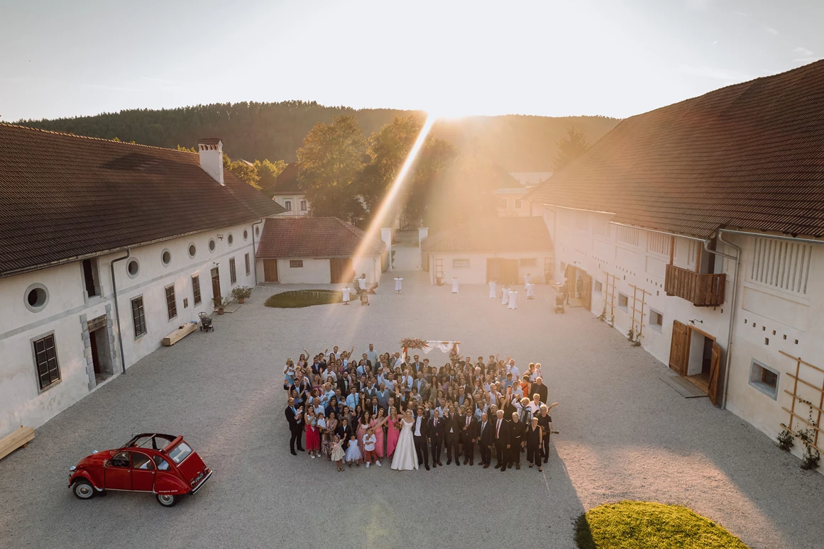 Hochzeit: Alte Meierei Bleiburg - Innenhof mit Hochzeitsgesellschaft Drohne - ALTE MEIEREI BLEIBURG