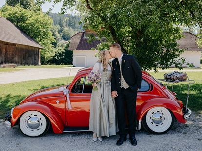 Hochzeit - PLZ 9155 (Österreich) - Paar mit rotem VW Käfer, Wirtschaftsgebäude hinter der Meierei. - ALTE MEIEREI BLEIBURG