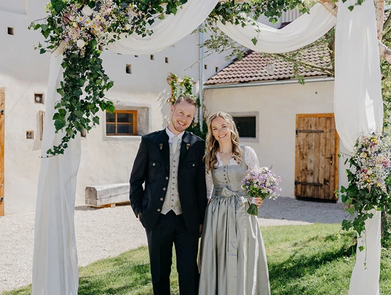 Hochzeit: Paar unter Brautbogen im Innenhof der Alten Meierei. - ALTE MEIEREI BLEIBURG