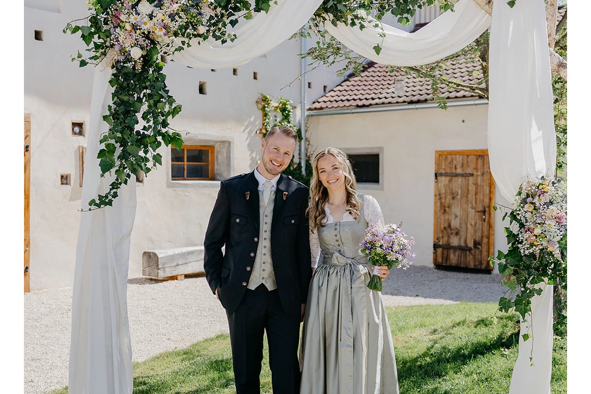 Hochzeit: Paar unter Brautbogen im Innenhof der Alten Meierei. - ALTE MEIEREI BLEIBURG