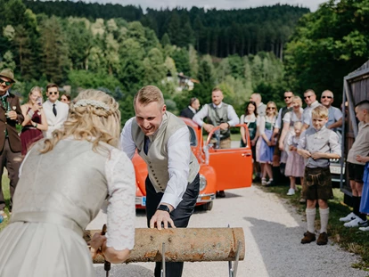 Hochzeit - PLZ 9155 (Österreich) - Brautpaar zersägt Holzbloch im Eingang zur Alten Meierei. - ALTE MEIEREI BLEIBURG