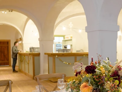 Hochzeit - PLZ 9155 (Österreich) - Festlich gedeckter Tisch im Saal mit Bar im Hintergrund / Alte Meierei Bleiburg - ALTE MEIEREI BLEIBURG