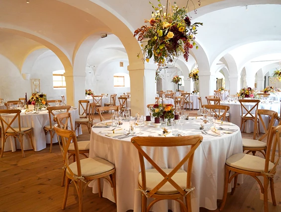 Hochzeit: Festlich gedeckte Tische im Saal mit Blumenschmuck in den Gewölben  I Alte Meierei Bleiburg - ALTE MEIEREI BLEIBURG