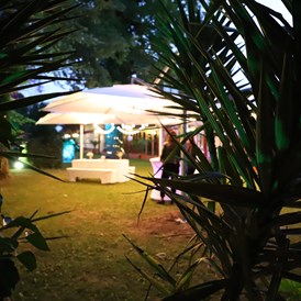 Hochzeit: Laue Sommernacht auf dem Jägerhof mit beleuchteten Schirmen und Stehtischen, 
vor dem "Hochzeittszimmer" - Jägerhof Biblis