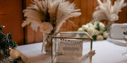 Bruiloft - Wiesloch - Stilvolle Hochzeitspost-Box mit goldenen Details und Trockenblumen im Wanderheim Germersheim. Auf einem weißen Tisch im festlich geschmückten Saal bietet sie Platz für Glückwunschkarten und persönliche Nachrichten der Gäste. - Wanderheim Germersheim
