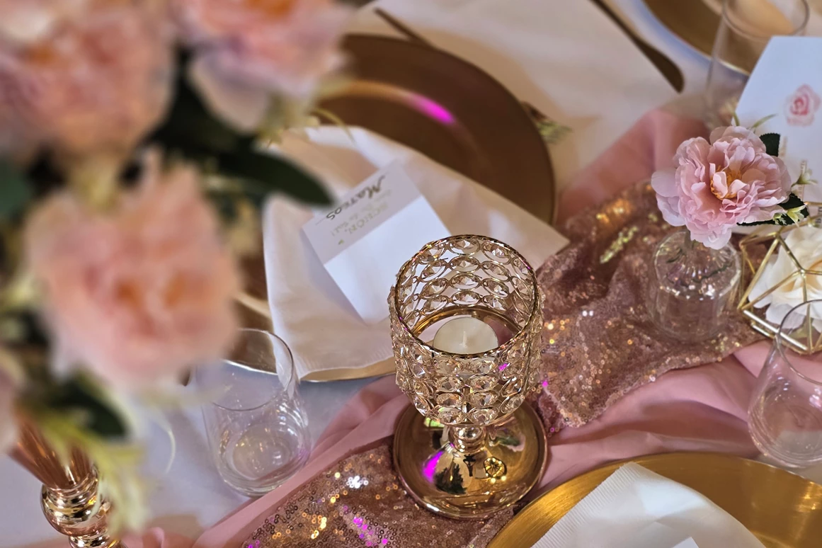 Hochzeitslocation: Detailaufnahme der edlen Tischdekoration mit goldenen Tellern, Servietten und zarten Rosé-Blumen. - Wanderheim Germersheim