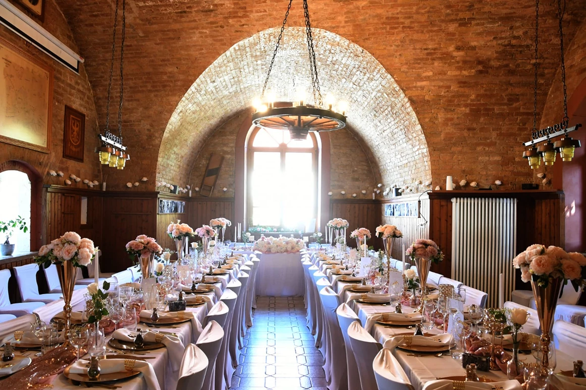 Hochzeitslocation: Heller Festsaal mit festlich gedeckten Tafeln, weißen Hussen und gold-roséfarbener Dekoration – ideal für Hochzeiten und Familienfeiern. - Wanderheim Germersheim