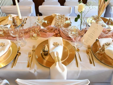 Hochzeitslocation: Elegant gedeckte Tische mit goldenen Akzenten und Rosé-Blumen – festliches Ambiente für Hochzeiten und Bankette. - Wanderheim Germersheim