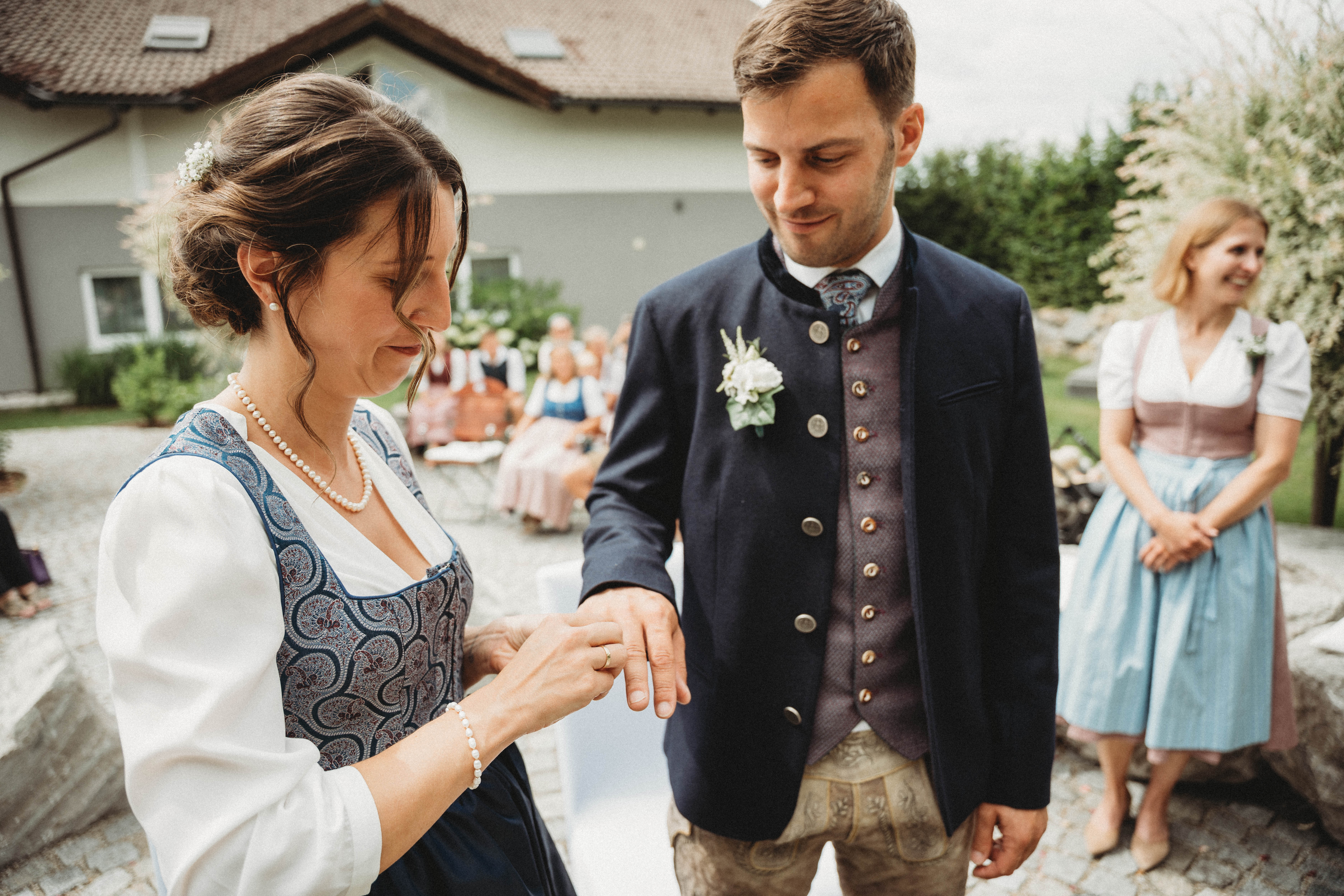 Hochzeitslocation: Brautpaar beim emotionalen Ringwechsel während einer freien Trauung in Österreich. Authentischer Hochzeitsmoment bei einer stilvollen Sommerhochzeit mit romantischer Atmosphäre, eleganter Hochzeitsdekoration und persönlicher Zeremonie in der exklusiven Hochzeitslocation PATRIX. - PATRIX Hotel | Restaurant | Bar